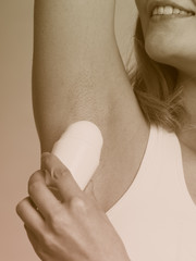 Wall Mural - Girl applying stick deodorant in armpit.