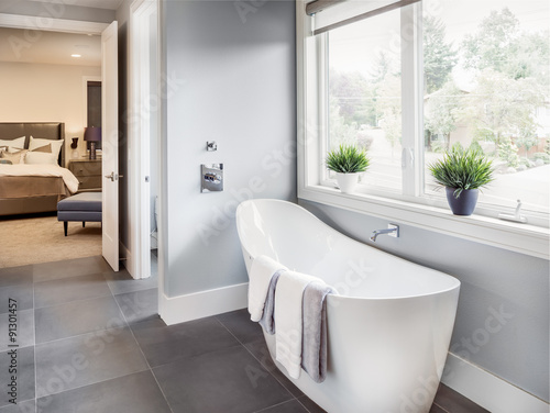 Valokuva Bathtub in master bathroom in new luxury home with view of master bedroom