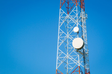 Close-up of a telecommunications tower with blue clear sky and c