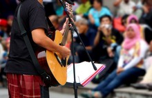 Street Musician With Guitar, With Audience In Background