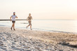 © kurapatka - Running people - woman and man athlete runners jogging on beach. Fit young fitness couple exercising healthy lifestyle outdoors during sunrise or sunset