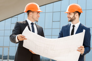 Two engineers checking the architectural plans