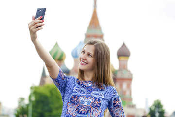 Wall Mural - Happy beautiful girl photographed on a cell phone