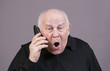 © maylat - Very emotional man with the telephone handset screams on a gray background