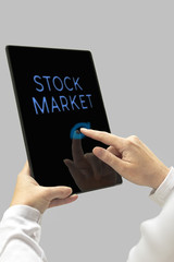 Stock Market message on digital tablet computer display. Woman h