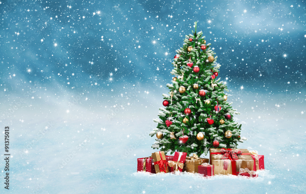 Weihnachtsbaum bei Schneefall mit Geschenken Stock Photo