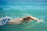 Fototapeta Łazienka - A man swims in the open sea