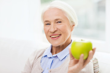 Sticker - happy senior woman with green apple at home