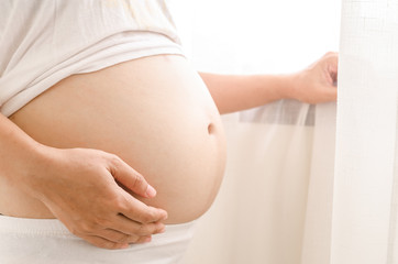 Close up pregnant women touching her belly with hands