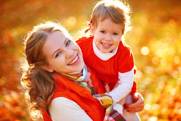 Wall Mural - happy family: mother and child little daughter play cuddling on