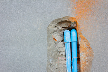 bury a pvc pipe in the concrete wall with copyspace on the left.