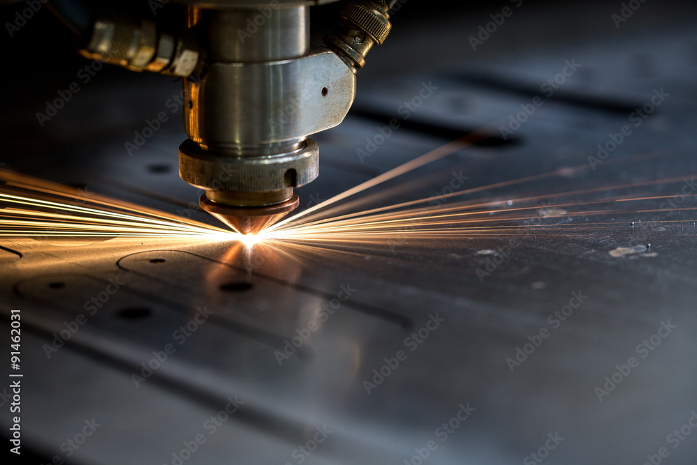 Cutting of metal. Sparks fly from laser - obrazy, fototapety, plakaty 