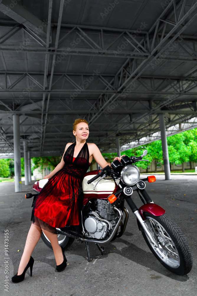 Biker girl in dress on a motorcycle over the background of dark Stock Photo  | Adobe Stock