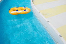 Yellow Rubber Ring Floating On Refreshing Blue Water