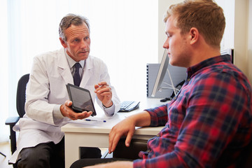 Wall Mural - Patient Having Consultation With Male Doctor In Office