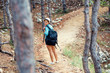 © aboutmomentsimages - female with backpack trekking on mountains, walking and running through forest and hills. Happy woman, ready for adventure exploring the nature