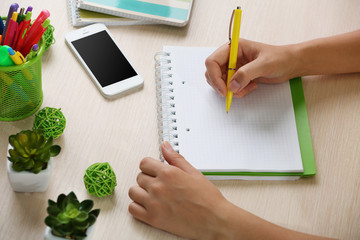 Wall Mural - Woman write on notebook on workplace close up