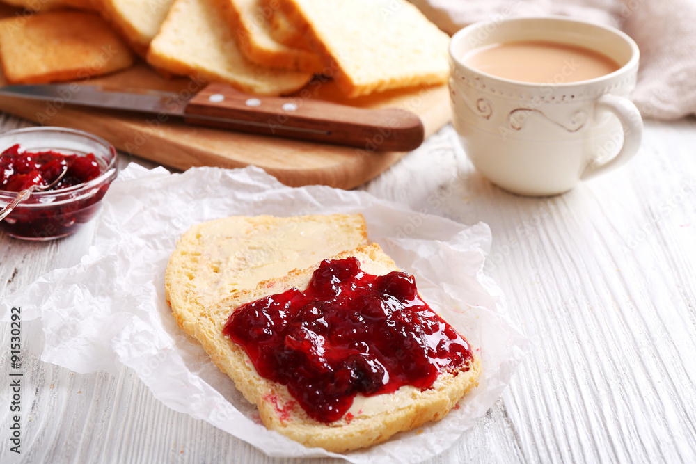 Bread with butter and homemade jam on crumpled parchment, closeup