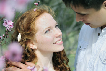 Fototapete - beautiful young couple in love among the flowering trees