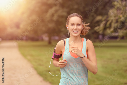Foto Hübsche Frau macht Joggen im Park mit Smartphone