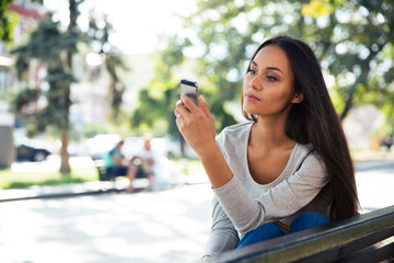 Sticker - Woman using smartphone on the bench outdoors