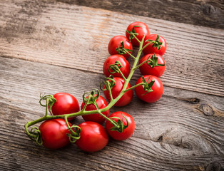 branch of tomatoes on a wooden background