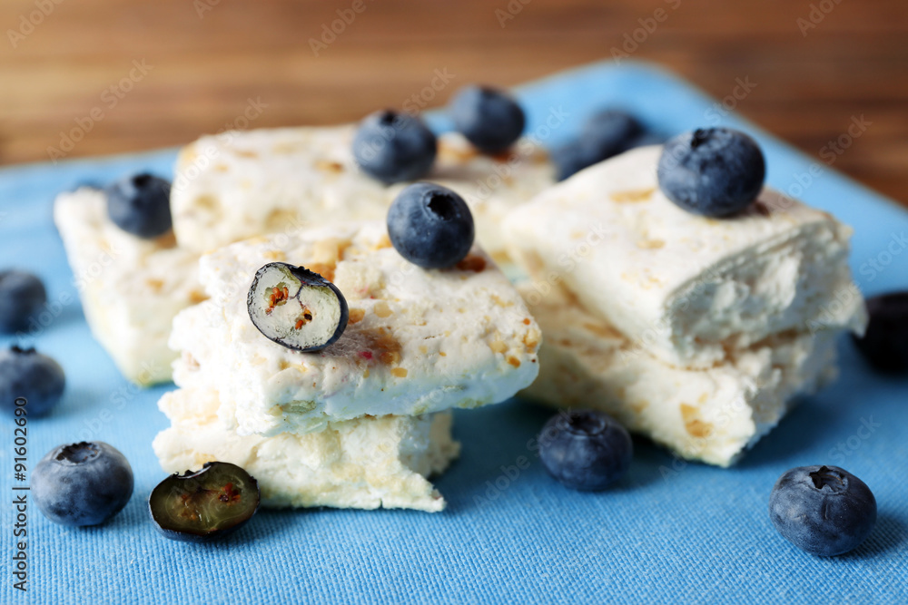 Sweet nougat with nuts and blueberries on napkin close up