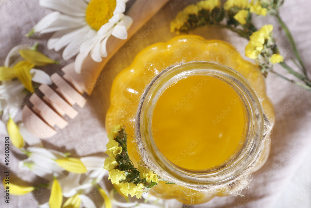 Honey and flowers on napkin top view