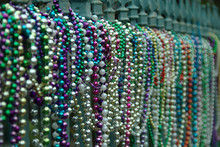 Alignment Of Multiple Colored Beads On A Fence In New Orleans In Louisiana After The Mardi Gras Party