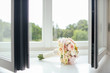 Elegant bridal bouquet of roses in light colors and pearl beads decoration lying on the windowsill.