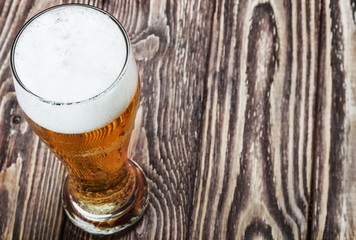 glass of fresh light beer on a wooden table