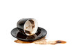 spilled coffee in inverted black Cup with a saucer isolated