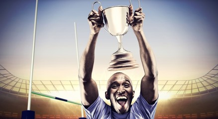 Poster - Composite image of happy athlete cheering while holding trophy