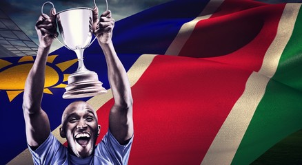 Poster - Composite image of happy athlete cheering while holding trophy