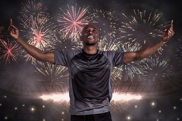 Wall Mural - Composite image of happy sportsman with arms raised