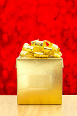 Golden Present box at red bokeh light background, Leave space fo