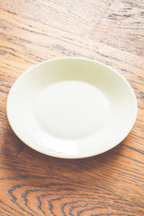 Poster - Empty white plate on wood background - vintage filter