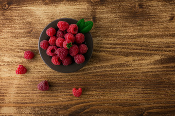 Wall Mural - raspberries in bowl on wood  table