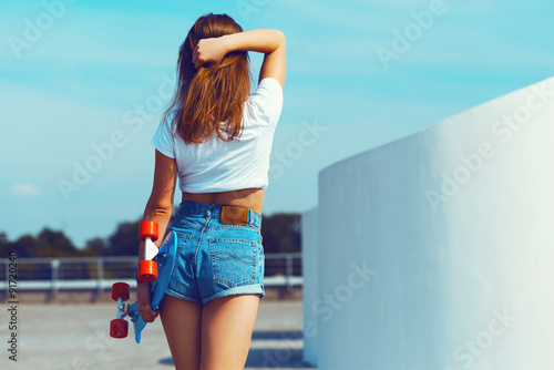 Beautiful sexy young girl in short shorts walking with longboard in ...