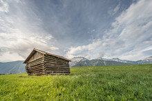 Old Wooden Farm Shed Hut At Green Meadow And Mountains