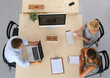 © shefkate - Top view of a business team sitting at a table for discussion.