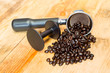 An espresso machine group head and coffee beans with tamper.