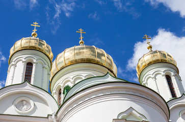 Canvas Print - Golden domes of Russian orthodox church with cross against blue