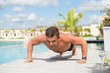© Kaspars Grinvalds - Man exercise and doing push ups by the pool