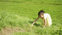 4K Little Girl In A Yellow Dress Climbs Up A Grassy Hill On A Bright Day, Shot On Red Epic Dragon