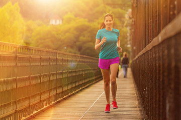 Running woman during sunny day in the city.