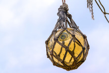 Historical Yellow Glass Fishing Float Ball Hanging In A Net To D