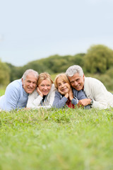 Canvas Print - Portrait of senior people laying in grass