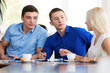 © kanzefar - Young businessmen sitting at a desk in the office, in the negoti