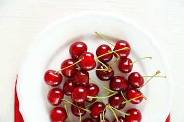Wall Mural - Sweet cherries on plate, on light background